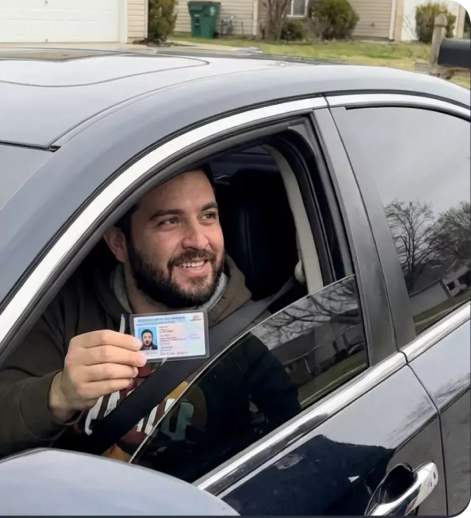Driver holding a medical window tint exemption card in their vehicle